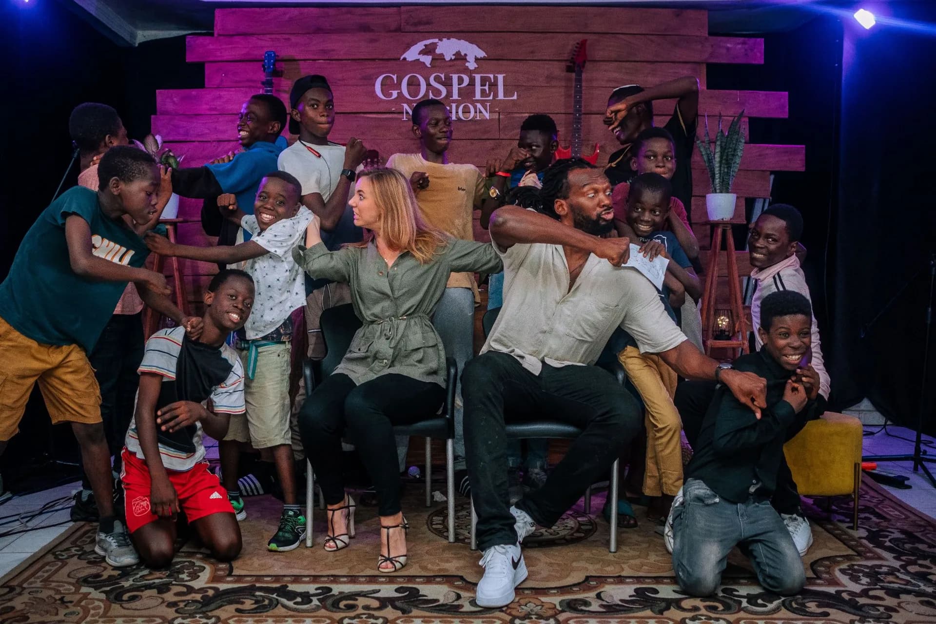 Le pasteur, sa femme et les enfants de One Love, hilares devant la caméra.