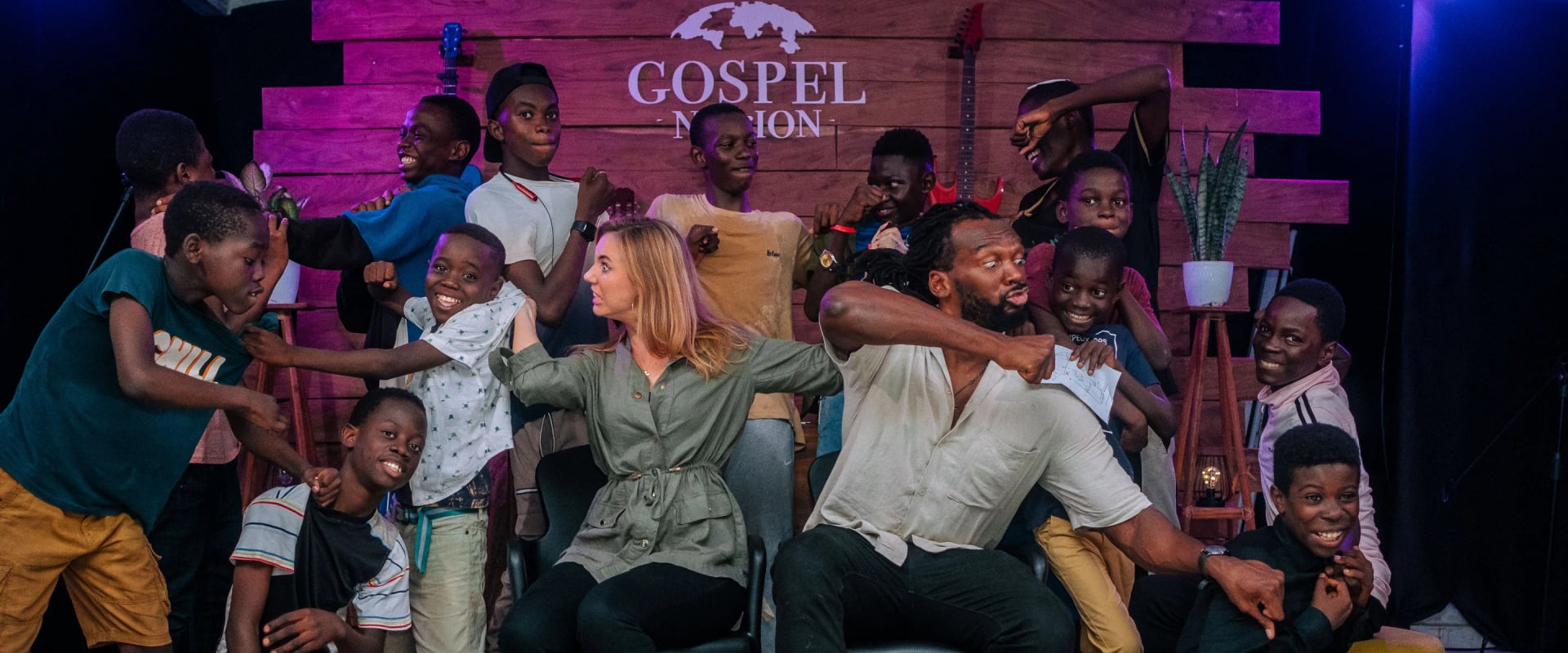 Le pasteur, sa femme et les enfants de One Love, hilares devant la caméra.