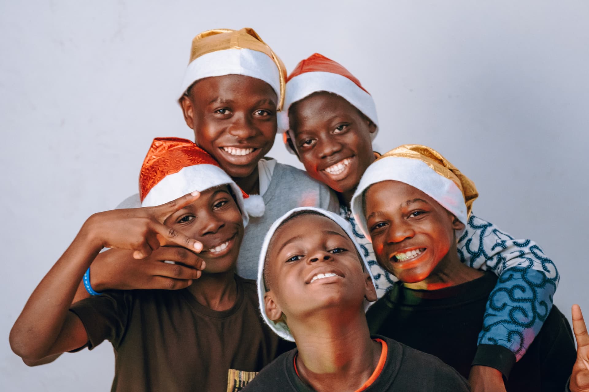 Cinq One Love Boys en bonnet de Noël, souriants.