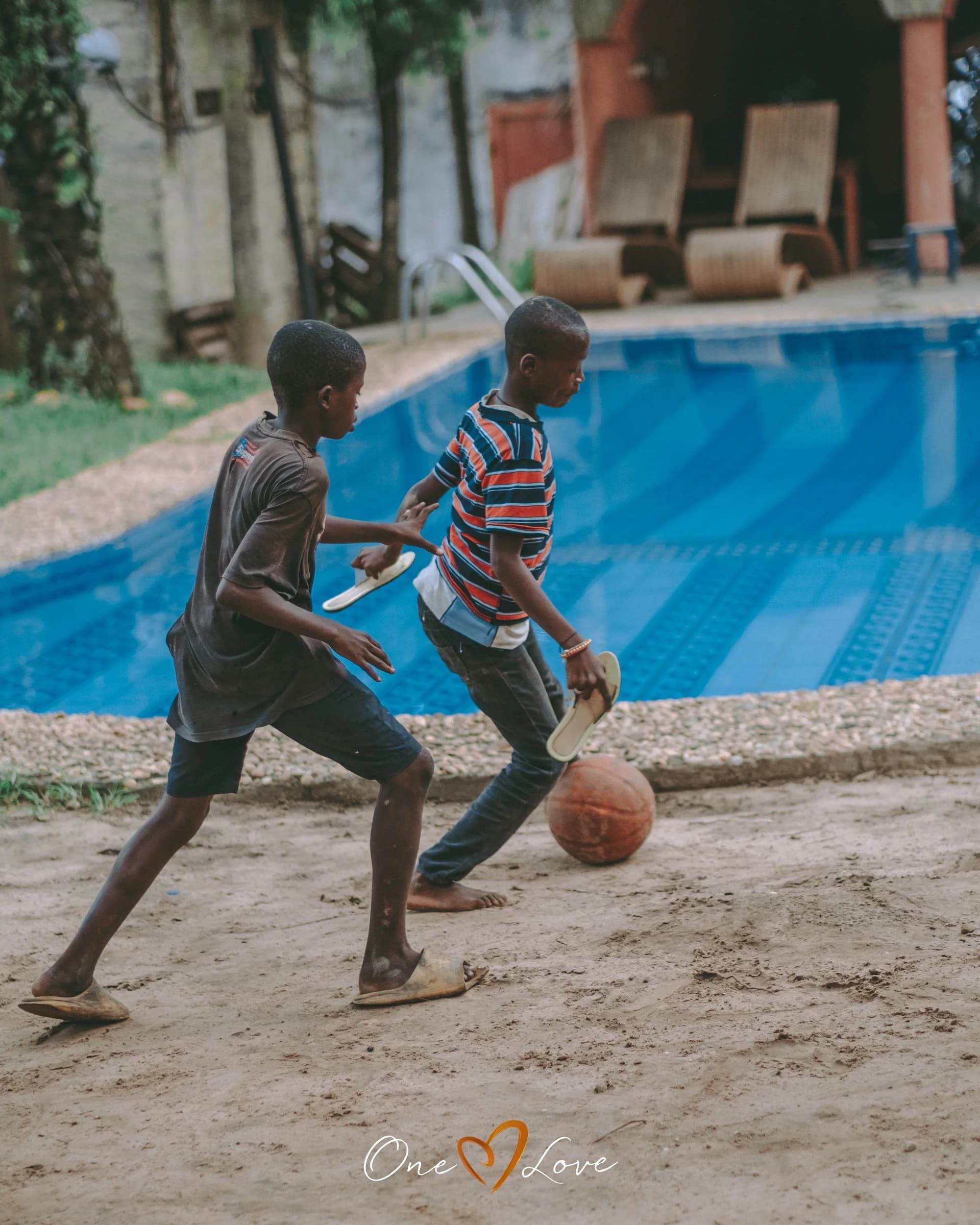 Des garçons jouent au basket dans la cour.
